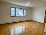 Spacious living room of a large 2 bedroom apartment with hardwood floors and bright natural light.