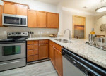 Modern kitchen with stainless steel appliances and granite countertops in Rose Heights Apartments, Raleigh, NC.