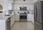Modern kitchen in a luxury apartment featuring stainless steel appliances and granite countertops.