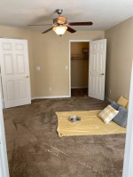 Cozy apartment interior at The Park at Catania with beige walls and carpeted floor, perfect for comfortable living.