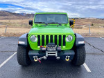 Front view of a 2018 Jeep Wrangler Rubicon in vibrant green color, parked in an outdoor setting.