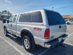 2005 Ford F-250 Diesel Lariat in silver with low mileage, perfect for towing, parked in a lot.