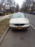 Front view of a 2001 Buick Century parked on the street with 139,000 miles, needing some repairs.