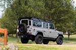 1993 Land Rover Defender 110 in Nardo Grey with black interior parked in a scenic garden setting