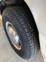 Close-up of a tire on a 2005 Ford E250 work van, showcasing good tread and chrome rim.