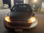 Front view of a 2008 Honda CRV with headlights on, parked at a car wash.