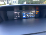Dashboard display of a 2015 Subaru XV Crosstrek Hybrid showing temperature and MPG details