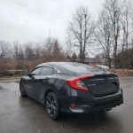Black Honda Civic Sport with 18-inch alloy wheels and LED lights parked in a gray outdoor setting
