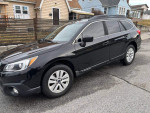 2017 Subaru Outback 2.5i, black color, parked on street, showcasing its all-wheel drive and spacious design