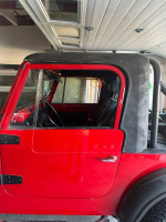 1976 Jeep CJ7 in excellent condition, red with manual transmission and 4WD, showcased in a garage setting.