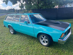 1978 Chevrolet Malibu Custom Wagon in teal and black, showcasing its unique paint and classic design on a grassy field.