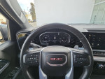 Interior view of a 2023 GMC Sierra 1500 showing the dashboard and steering wheel details.