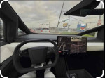 Interior view of a Tesla Model Y with a digital dashboard and steering wheel in urban setting.