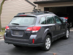 2012 Subaru Outback 2.5i AWD, rear view parked in driveway, well-maintained and ready for cross-country driving.