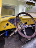 Interior view of a 1955 Chevy 3100 showcasing steering wheel and dashboard details