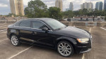 2015 Audi A3 in black parked on rooftop with city skyline in the background, features 113,000 miles and clean leather interior.