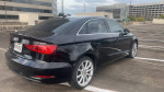 2015 Audi A3, sleek black sedan with alloy wheels, parked in an open lot, showing clean design and elegant shape.