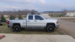 2015 Chevrolet Silverado 1500 LT 4WD with Z71 package, black rims, and large mirrors parked outdoors