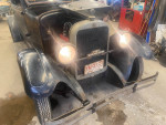 1928 Dodge Brothers sedan in a garage, displaying its vintage design and headlights.