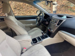 Interior view of a 2011 Subaru Outback with beige upholstery and modern dashboard features.