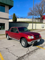 2001 Ford Sport Trac in red parked outside, a reliable one-owner work truck with wear and tear.