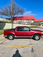 2001 Ford Sport Trac in red color parked, ideal work truck with 197k miles, one owner, well-maintained.