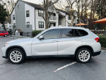 2015 BMW X1 xDrive28i AWD in silver color parked outside residential buildings