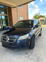 2011 Volkswagen Tiguan in good condition with new tires and spark plugs, parked outside a modern building