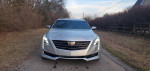 Front view of a 2018 Cadillac CT6 Luxury sedan parked on a rural road, showcasing its sleek design and modern lighting.