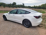 2021 Tesla Model 3 Standard Range Plus in white, parked in scenic outdoor setting, showcasing sleek design and aerodynamic profile.