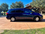 2006 Toyota Sienna LE minivan in dark blue, showcasing side view with tinted windows and clean exterior.