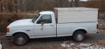1991 Ford F150 truck in good condition with an 8-foot bed and side boards, parked outdoors.