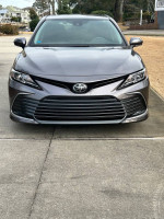 Front view of a 2023 Toyota Camry LE in excellent condition, showcasing its sleek design and low mileage.