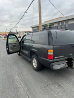 Chevrolet Suburban with open door parked on street, reliable vehicle with clean CarFax and in excellent mechanical condition.
