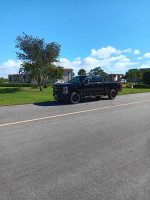 2023 Ford F-350 Super Duty Crew Cab XLT in perfect condition parked on a sunny street with a clear blue sky.