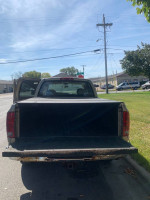 Rear view of a 2005 Dodge Ram 1500 SLT truck parked on a street, showcasing its spacious bed.