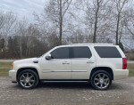 Side view of a 2007 Cadillac Escalade with 22-inch wheels, showcasing its sleek design and spacious interior.