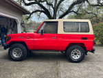 1993 Toyota Landcruiser BJ FJ 73 4X4 in red with a tan top, parked in a Sacramento driveway