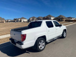 2010 Honda Ridgeline 4WD parked on a street, showcasing its sleek design and clean exterior in Leander, TX.