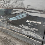 Close-up of a 2017 BMW X3 xDrive28i with minor scratches and dents on the side panel.
