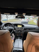 Interior view of a 2010 Mercedes-Benz E-Class E550 with leather seats and navigation system.