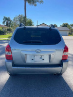 Rear view of a silver 2008 Hyundai Tucson with clean design and new tires, parked in bright daylight.