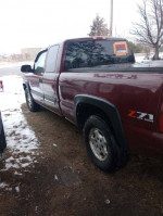 Side view of a maroon Chevy Silverado 1500 4x4 truck parked on grass, showing its clean condition and Z71 badge.