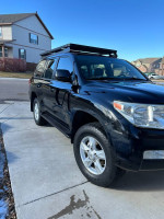 2008 Toyota Land Cruiser in black with roof rack parked on driveway