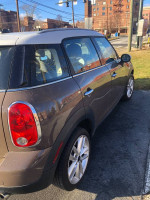 2012 MINI Cooper Countryman parked, showcasing its clean exterior and alloy wheels, well-maintained with 120,000 miles.