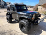 2006 Jeep Wrangler 4x4 with 35-inch tires and new soft top parked in driveway