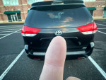2014 Toyota Sienna XLE in a parking lot, showing minor body damage and new tires, inspected for safety.
