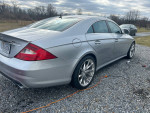Silver 2006 Mercedes CLS55 with custom forged wheels parked on gravel