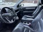 Interior view of 2010 Honda CR-V EX with leather seats and steering wheel, showing dashboard controls and spacious design.
