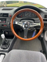 Interior view of a 1997 Honda Civic with wooden steering wheel and manual gear shift